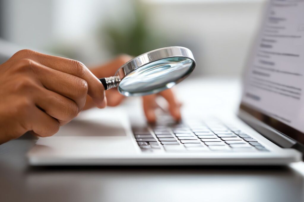 SEO on-page para afiliados simbolizado por lupa sobre teclado de notebook