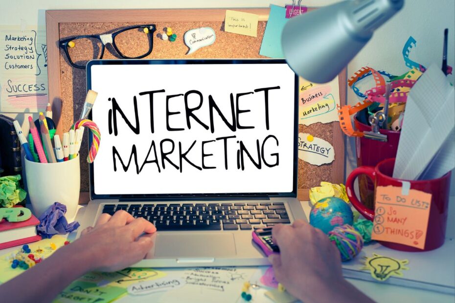 Laptop com a mensagem Internet Marketing em uma mesa de trabalho descontraída. O foco no marketing de afiliação.