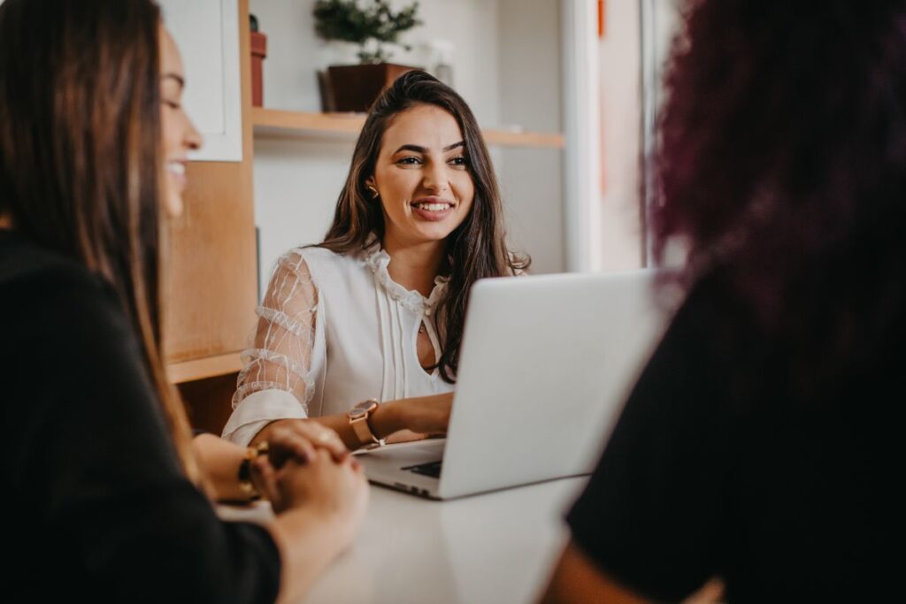 Mulher sorridente em uma reunião, demonstrando a satisfação de trabalhar com Marketing de Afiliados e compartilhar conhecimento.