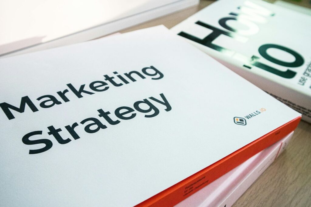 Profissional acompanhando gráficos de performance em smartphone enquanto analisa dados complementares no laptop ao fundo, demonstrando o monitoramento multiplataforma essencial para afiliados. A imagem ilustra a facilidade de acesso aos relatórios da plataforma de afiliados em qualquer dispositivo, permitindo acompanhar em tempo real cliques, conversões e comissões. Essa praticidade no acompanhamento de métricas foi fundamental para ajustar estratégias rapidamente e conquistar vendas nos primeiros dois dias de trabalho com marketing de afiliação digital.