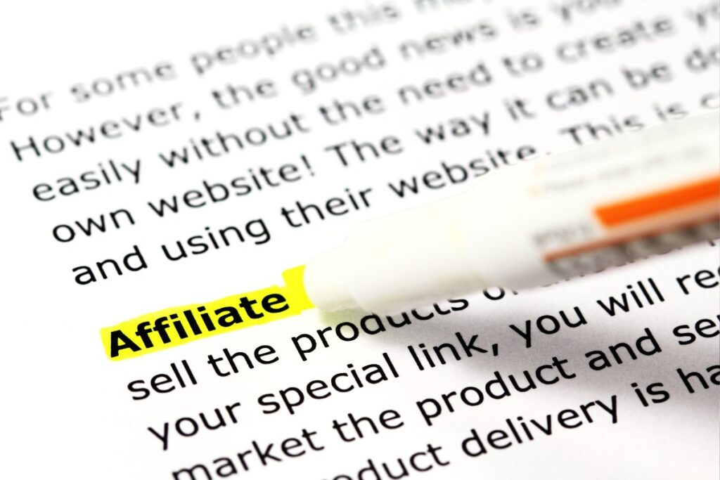 Palavra "Affiliate" destacada em amarelo em texto sobre marketing, com marcador laranja - conceito de palavras-chave para afiliação
