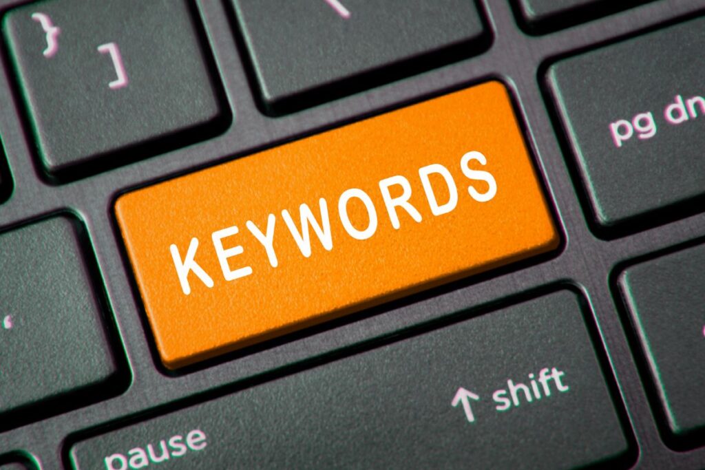 Tecla laranja "KEYWORDS" destacada em teclado de computador, simbolizando acesso direto a ferramentas de pesquisa para afiliados