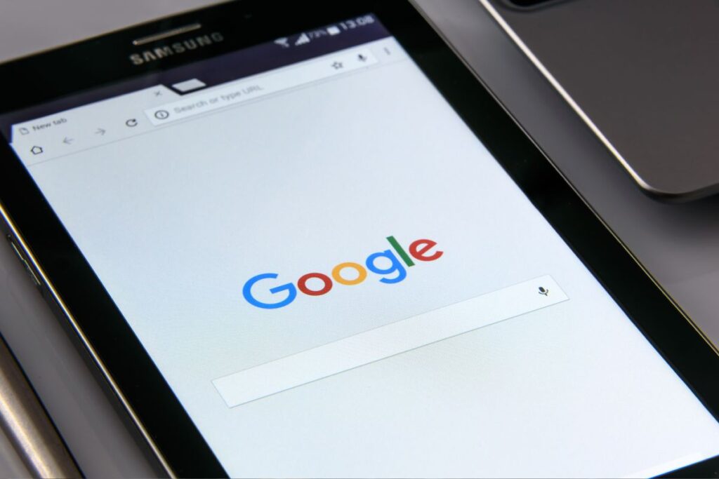 Tablet Samsung em close exibindo a página inicial do Google. A imagem destaca a importância da otimização para dispositivos móveis, como o ranqueamento é feito em diferentes telas.