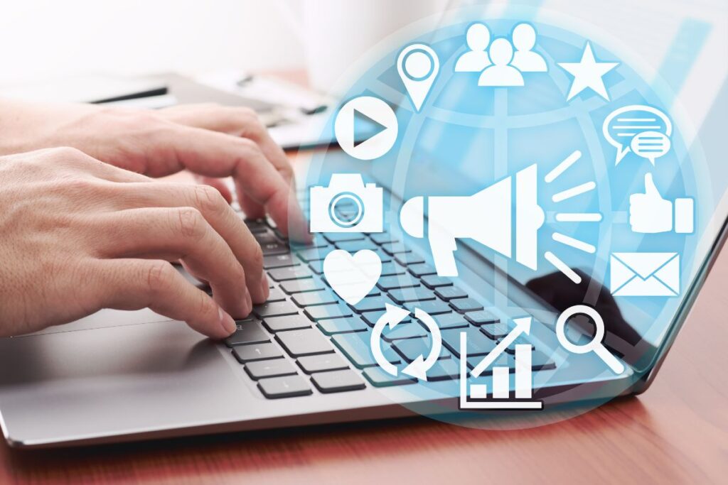 Mãos digitando em laptop com ícones de marketing digital flutuando, representando a realidade do trabalho multitarefa no marketing de afiliados