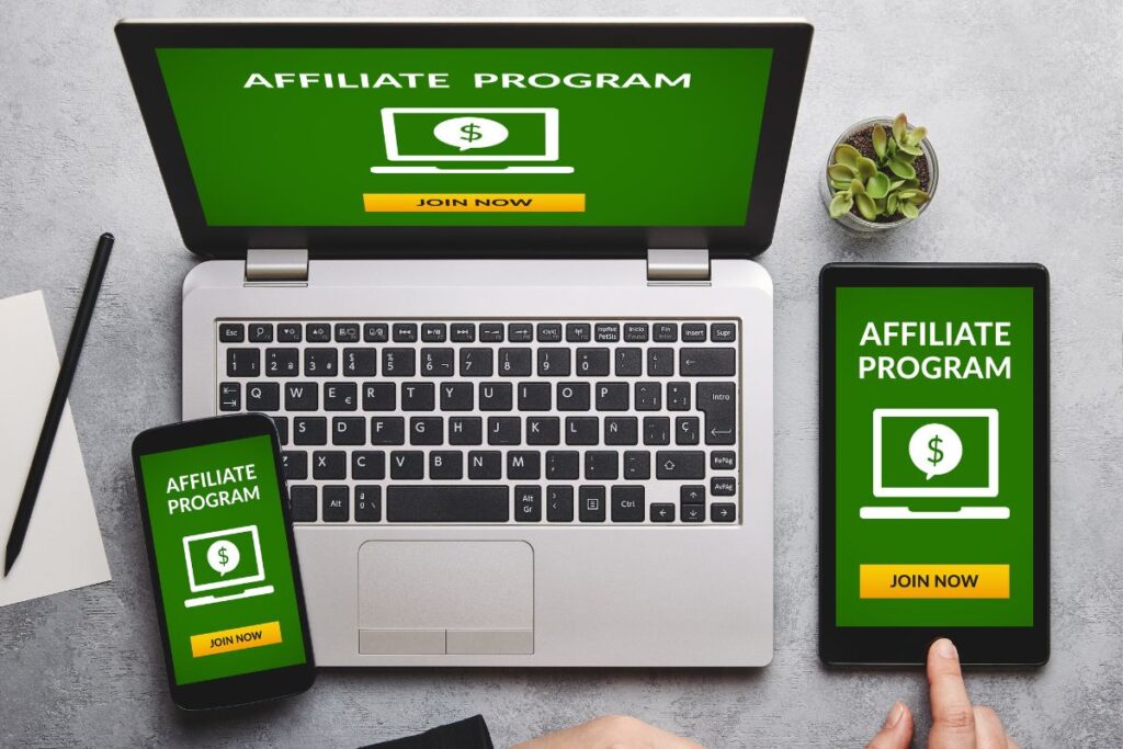 Dispositivos múltiplos exibindo programas de afiliados com botões "JOIN NOW", mostrando a realidade da presença digital necessária no marketing de afiliados