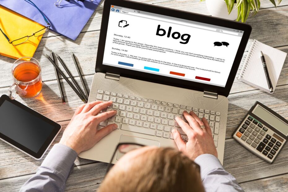 Visão aérea de uma pessoa usando ferramentas para blog em um computador.