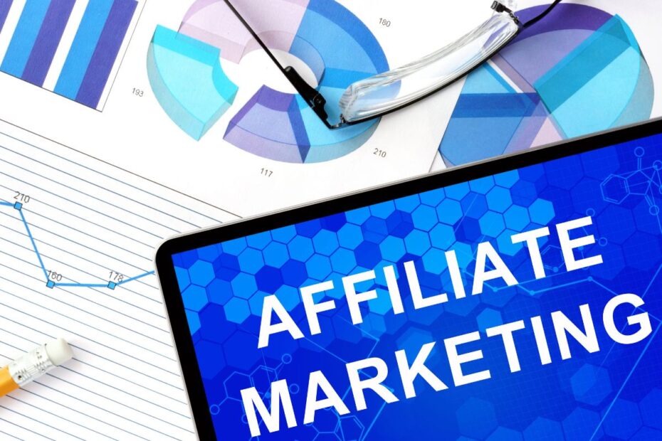 Laptop exibindo "Affiliate Marketing" com gráficos e relatórios de performance de plataforma de afiliados ao fundo