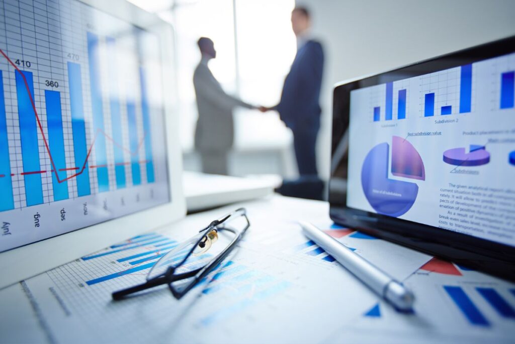 Escritório corporativo com monitores exibindo gráficos de performance e analytics de plataforma de marketing de afiliados
