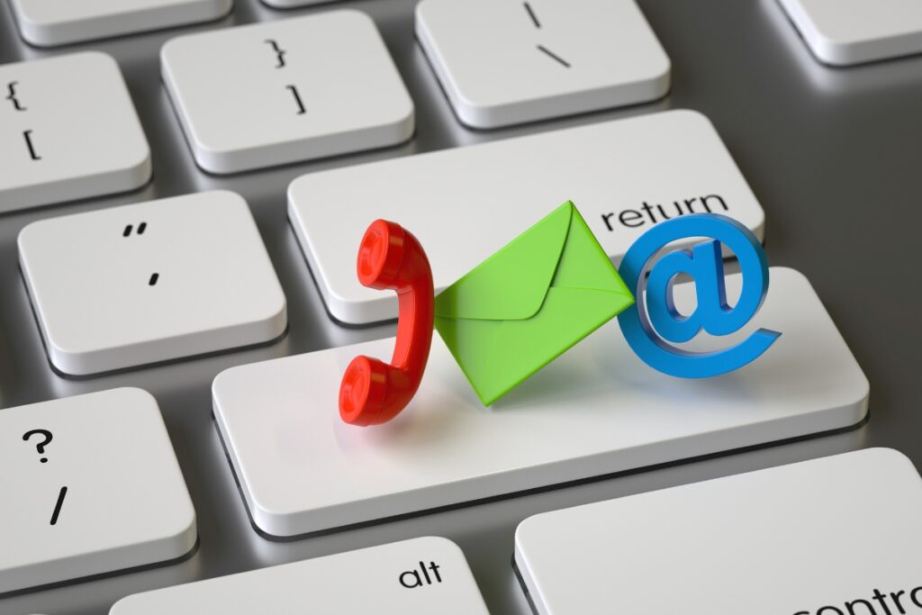 Ícones de contato sobre um teclado, representando a importância de criar uma lista de e-mail para atuar como afiliado de um nicho específico.