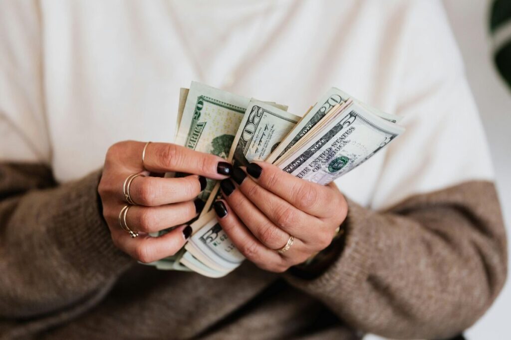 Afiliada segurando dinheiro representando comissões ganhas através de recursos de plataformas de afiliados