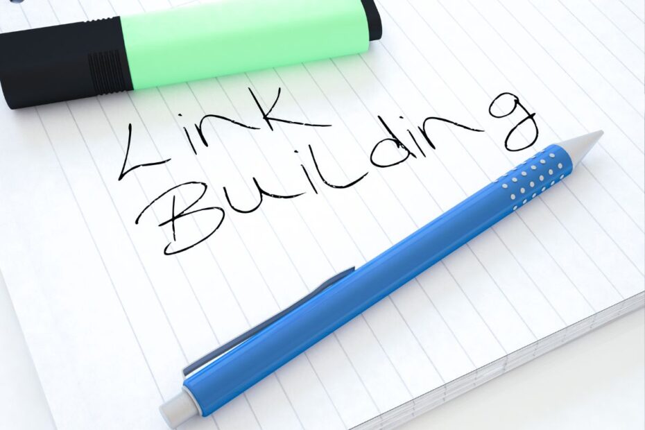 Link building escrito à mão em caderno com caneta azul, planejamento de backlinks para afiliados