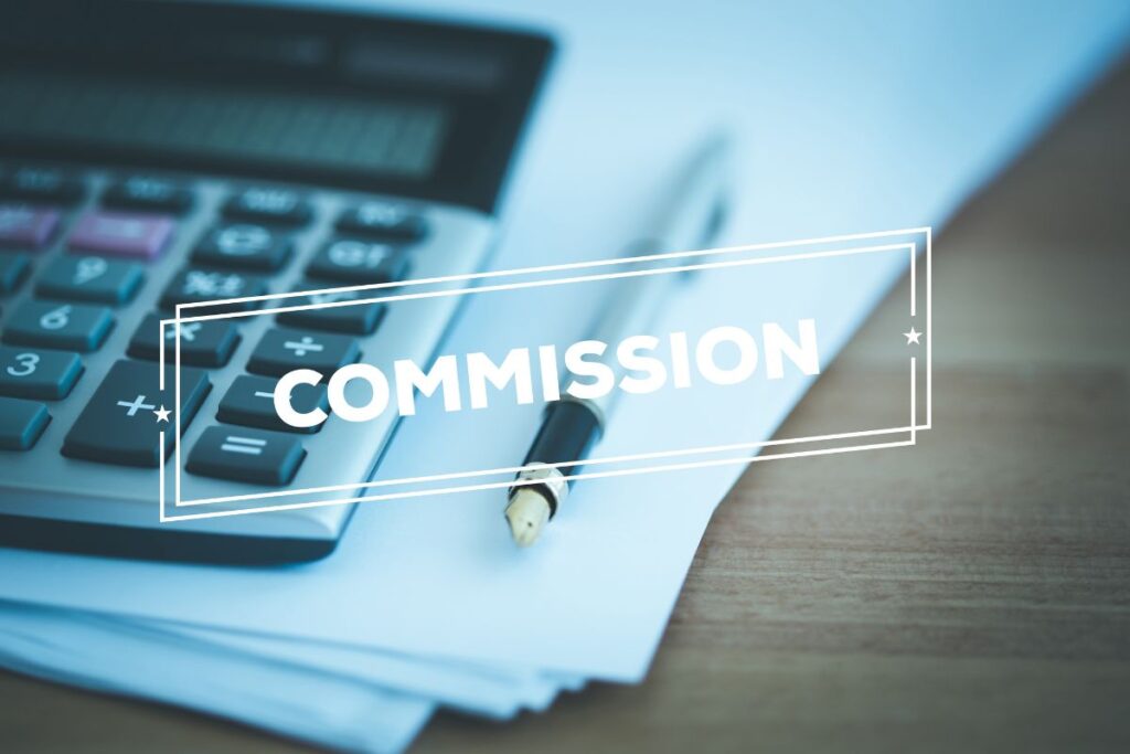 Calculadora e caneta em foco suave com a palavra "COMMISSION" em destaque, focando na importância do valor da comissão.