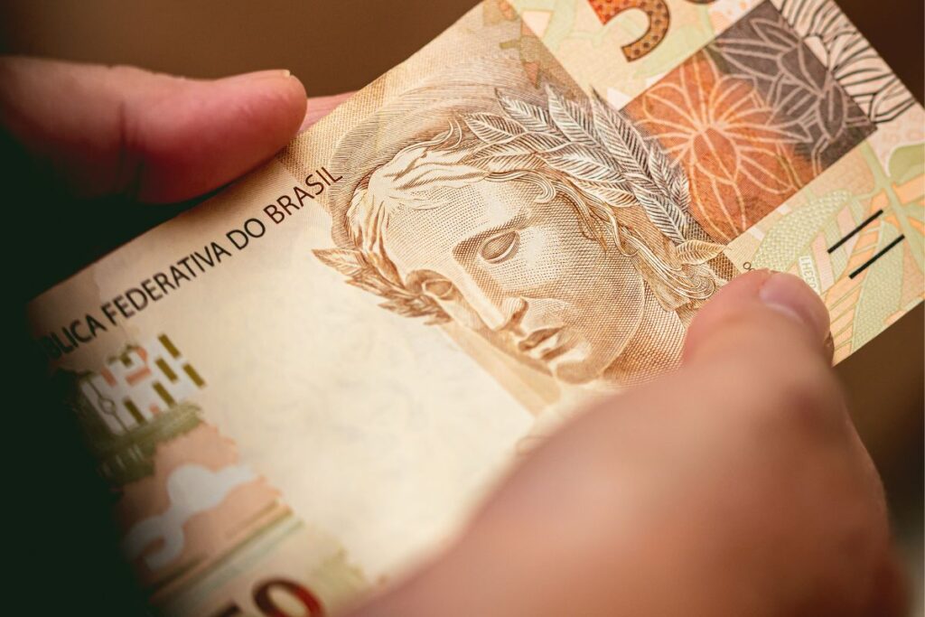 Pessoa segurando cédula de real brasileiro, simbolizando ganhos obtidos através de link de afiliado.