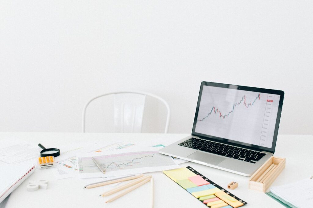 Home office minimalista com notebook exibindo um gráfico de alta de vendas, representando o sucesso com o programa de afiliados Awin.