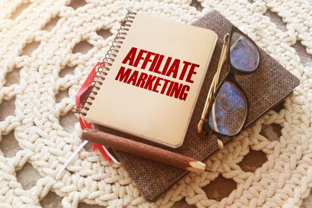 Caderno com "AFFILIATE MARKETING" em letras vermelhas sobre tecido, representando anotações e planejamento para o sucesso nas top plataformas de afiliados.