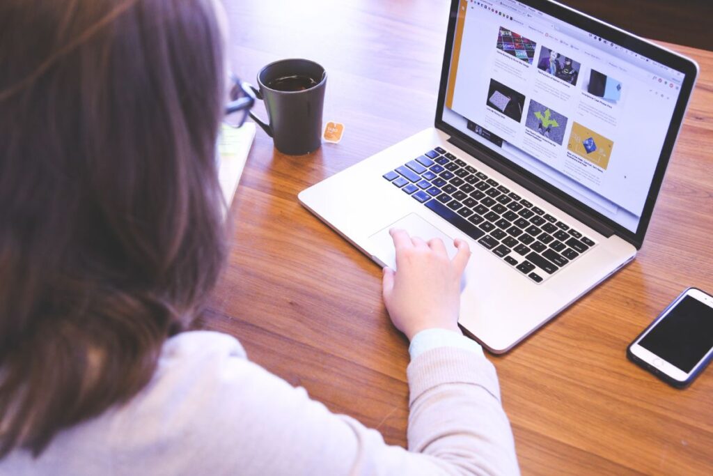 Mulher navegando em um laptop, focada na criação ou consumo de escritos, como posts de blog ou artigos detalhados.